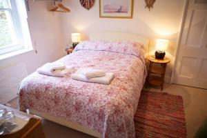 1 dormitorio con 1 cama con 2 toallas en The Cottage at Weston Lawn, en Bath