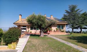 una casa con un árbol en el patio delantero en Resort Orizzonti, en SantʼElpidio a Mare