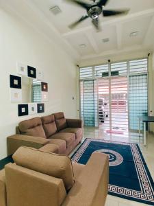 a living room with a couch and a ceiling fan at Rawyna homestay segamat in Segamat