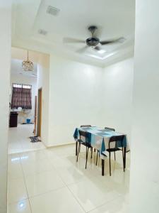a dining room with a table and a ceiling fan at Rawyna homestay segamat in Segamat