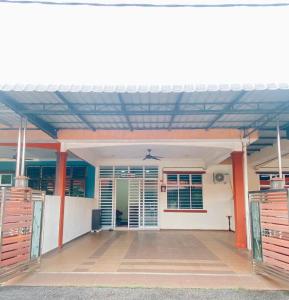 an open front porch of a house with red pillars at Rawyna homestay segamat in Segamat
