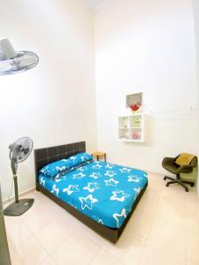 a bedroom with a bed and a desk and a fan at Rawyna homestay segamat in Segamat