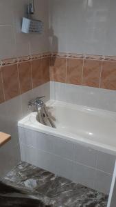 een wit bad met een kraan in de badkamer bij Apartment in residential complex with pool in Klorakas