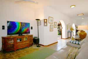 a living room with a couch and a flat screen tv at La Cocoteraie in Le Morne