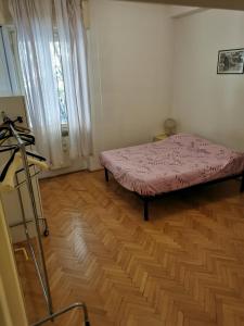 1 dormitorio con 1 cama y suelo de madera en La Luna sull'Adige, en Verona