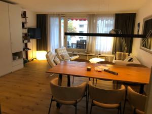 een woonkamer met een houten tafel en stoelen bij Nice Apartment private host Engelberg in Engelberg