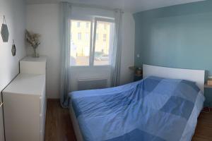 - une chambre avec un lit bleu et une fenêtre dans l'établissement Maison « Maracha » centre ville 150m de la plage, à Wimereux