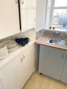 a kitchen with white cabinets and a sink at Sedgefield in Huddersfield