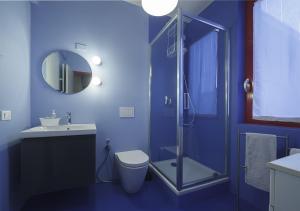a blue bathroom with a toilet and a shower at BBnaon in Pordenone