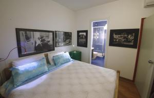 1 dormitorio con 1 cama y cuadros en la pared en BBnaon, en Pordenone