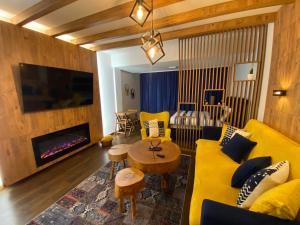 a living room with a yellow couch and a fireplace at Apartment Blue Eko Fis Vlašić in Vlasic