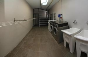 een wasruimte met een wasmachine en een wastafel bij ALBERGUE SAN MARCOS in Palas de Rei 