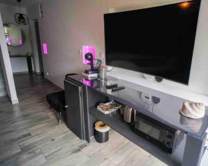 una grande TV a schermo piatto appesa a un muro di Superbe appartement avec balnéo. a Saint-Cyprien