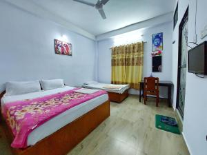 a bedroom with a bed and a table and a chair at Lumbini Garden Lodge in Lumbini