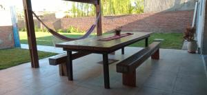 a wooden table with a hammock and a bench at Complejo SABEJO in San Antonio de Areco