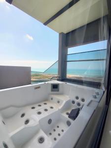 マラッカにあるImperio Homestay Private Bathtub-FreeParking & Wifiの海の景色を望むバスタブ