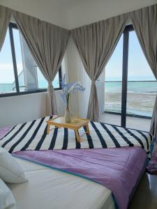 馬六甲的住宿－Imperio Homestay Private Bathtub-FreeParking & Wifi，一间卧室配有一张带桌子的床,享有海滩美景