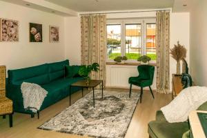salon z zieloną kanapą i oknem w obiekcie Apartmán Lukas s KRBEM v centru w Karwinie