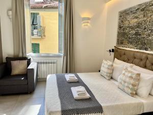 ein Schlafzimmer mit einem Bett mit einem Stuhl und einem Fenster in der Unterkunft Sunset rooms in La Spezia