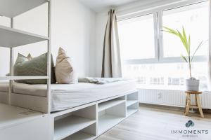 ein weißes Schlafzimmer mit einem Etagenbett und einem Fenster in der Unterkunft Serviced Apartment mit Netflix und WLAN im Zentrum in Magdeburg