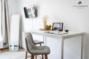 einen weißen Schreibtisch mit einem Stuhl und einem Laptop darauf in der Unterkunft Serviced Apartment mit Netflix und WLAN im Zentrum in Magdeburg