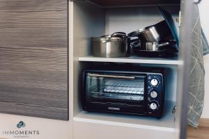 einen Toaster-Backofen in einer Küche mit Töpfen und Pfannen in der Unterkunft Serviced Apartment mit Netflix und WLAN im Zentrum in Magdeburg