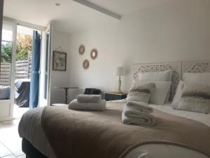 1 dormitorio blanco con 1 cama grande con almohadas blancas en LUVA d'Azur, Rez de villa LE RIOU - LE VALLON, en Le Bar-sur-Loup