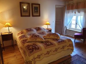a bedroom with a bed with two lamps and a window at Les Écuries in Frontenay-Rohan-Rohan