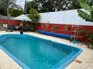 une grande piscine bleue dans une cour dans l'établissement VyvyRUN974, à Les Cocos