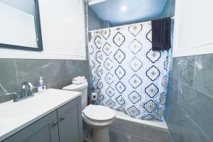 a bathroom with a toilet and a shower curtain at The Jackpot Cottage in Niagara Falls