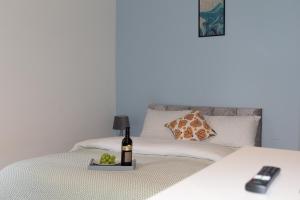 uma garrafa de vinho e um prato de fruta numa cama em Vion Apartment - King Suites em Aberdeen