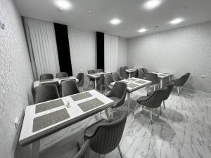 a dining room with tables and chairs in a room at Hotel Ulug'bek in Bukhara