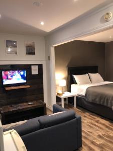 Habitación de hotel con cama y TV en Greenside Motel, en Saint Andrews