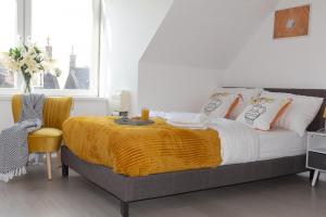 Vion Apartment - King Suites في أبردين: غرفة نوم عليها سرير مع بطانية صفراء