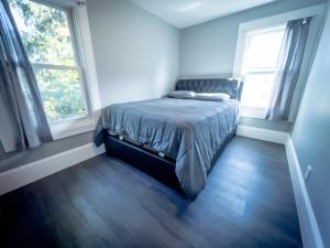 The Blue Chip Villa في شلالات نياغارا: غرفة نوم بسرير في غرفة بها نافذتين