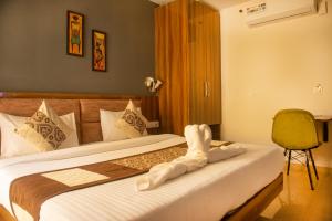 um quarto de hotel com uma cama com uma toalha em Posh Residency Artemis Hospital Road Gurgaon em Gurgaon