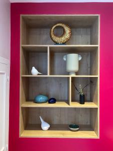 a wooden shelf with vases and a mirror at Suite avec Spa Quartier Cathédrale in Autun