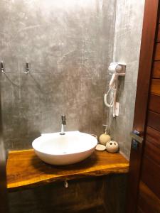 a bathroom with a white sink on a wooden counter at Vila Cris in Fernando de Noronha +27 photos