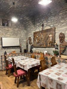 a dining room with two tables and a stone wall at Arthemisia in Rhêmes-Notre-Dame