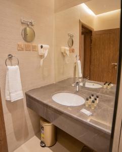 a bathroom with a sink and a mirror at DiYar Home Hotel in Baljurashi
