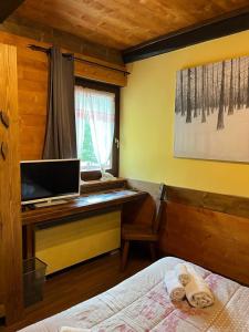 a bedroom with a computer desk and a bed at Arthemisia in Rhêmes-Notre-Dame