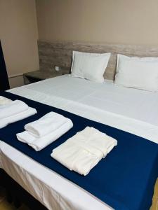 a large bed with white towels on top of it at MINI HOTEL COMFORT in Shymkent