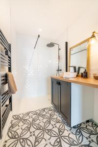 a bathroom with a glass shower and a vanity with a mirror at MAISON SWANNEL - Cosy & Spa in Andernos-les-Bains
