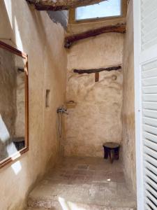 y baño con ducha en una pared de piedra. en Baben Home en Siwa