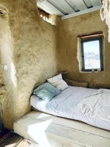 Cama pequeña en habitación con ventana en Baben Home, en Siwa