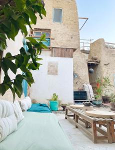 un patio con una cama y un banco y un edificio en Baben Home en Siwa
