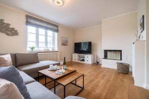 a living room with a couch and a table at Caras Hus in Midlum