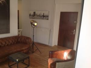 a living room with a leather couch and a spotlight at Appartement Cannes rue Marceau in Cannes