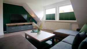 ein Wohnzimmer mit einem Sofa und einem TV in der Unterkunft Ferienwohnung Ravensberg Dachgeschoss in Bad Sachsa