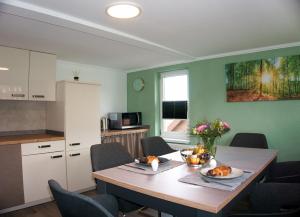 une cuisine avec une table en bois et des chaises ainsi qu'une salle à manger dans l'établissement Ferienwohnung Ravensberg Dachgeschoss, à Bad Sachsa